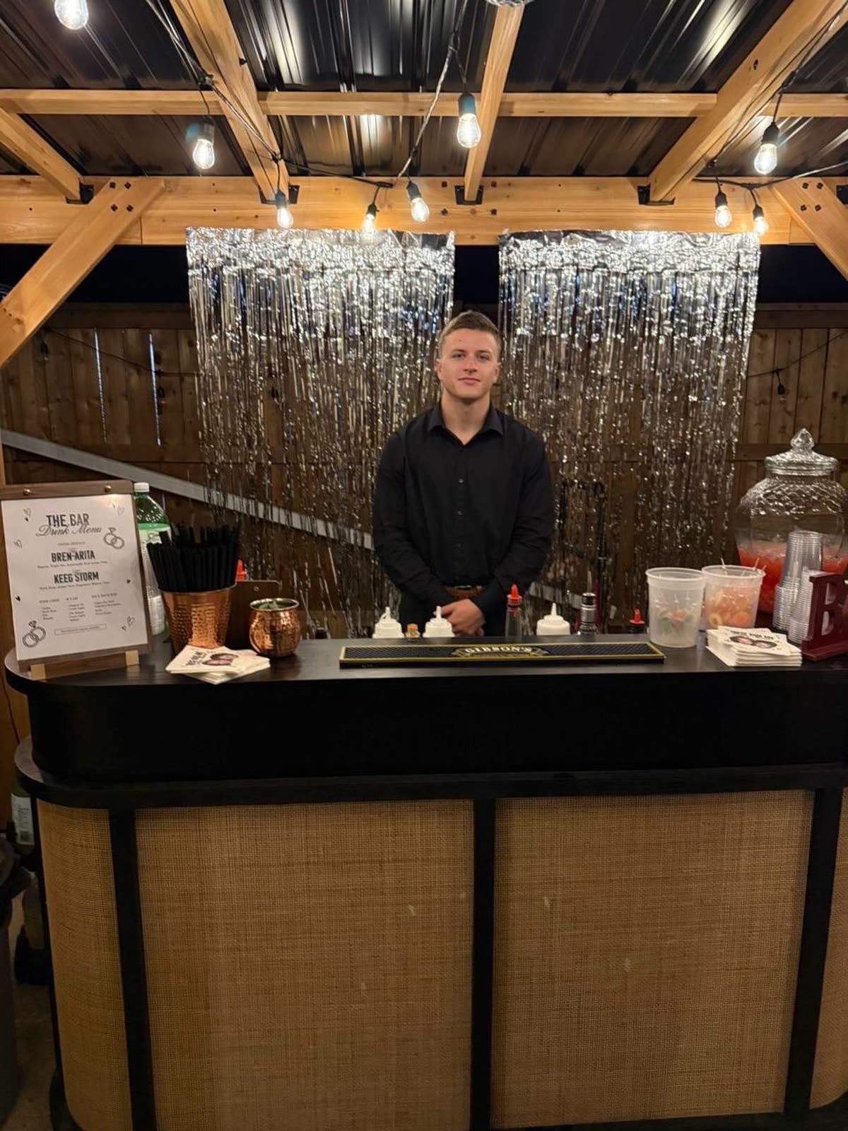 Bartender at the black pop-up bar with shimmer backdrop